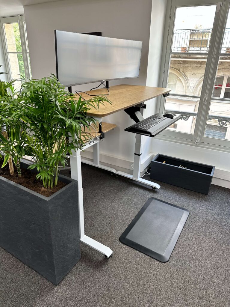 Station de travail : écran Dell Ultra Sharp de 49" Clavier et souris Logitech. Bureau sur vérin en position debout. Coworking Bordeaux. Coworking Iptek.