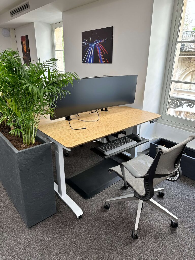 Station de travail : écran Dell Ultra Sharp de 49" Clavier et souris Logitech. Bureau sur vérin en position assise. Coworking Bordeaux. Coworking Iptek.